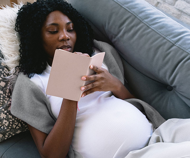 Pregnant Mom on couch making baby arrival checklist