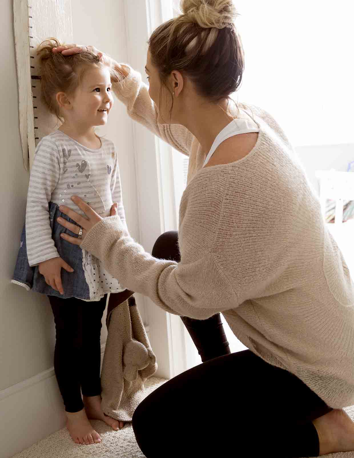 Mom measuring height of girl image