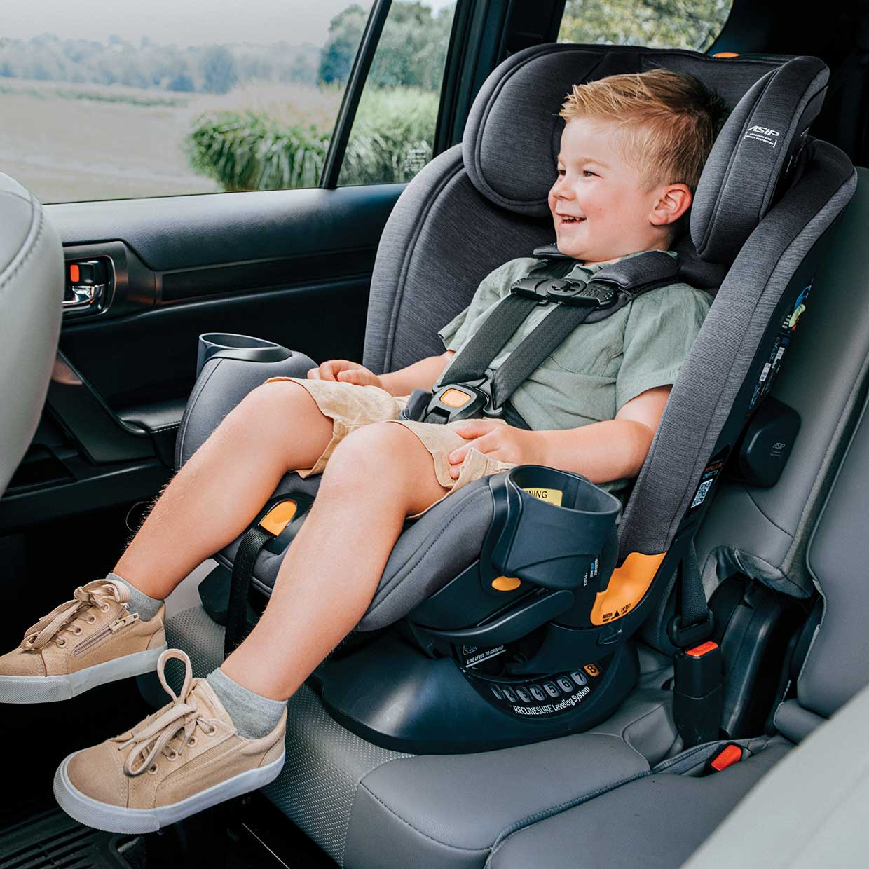 Toddler sitting in a Chicco OneFit LX ClearTex All-in-One Car Seat in forward-facing mode