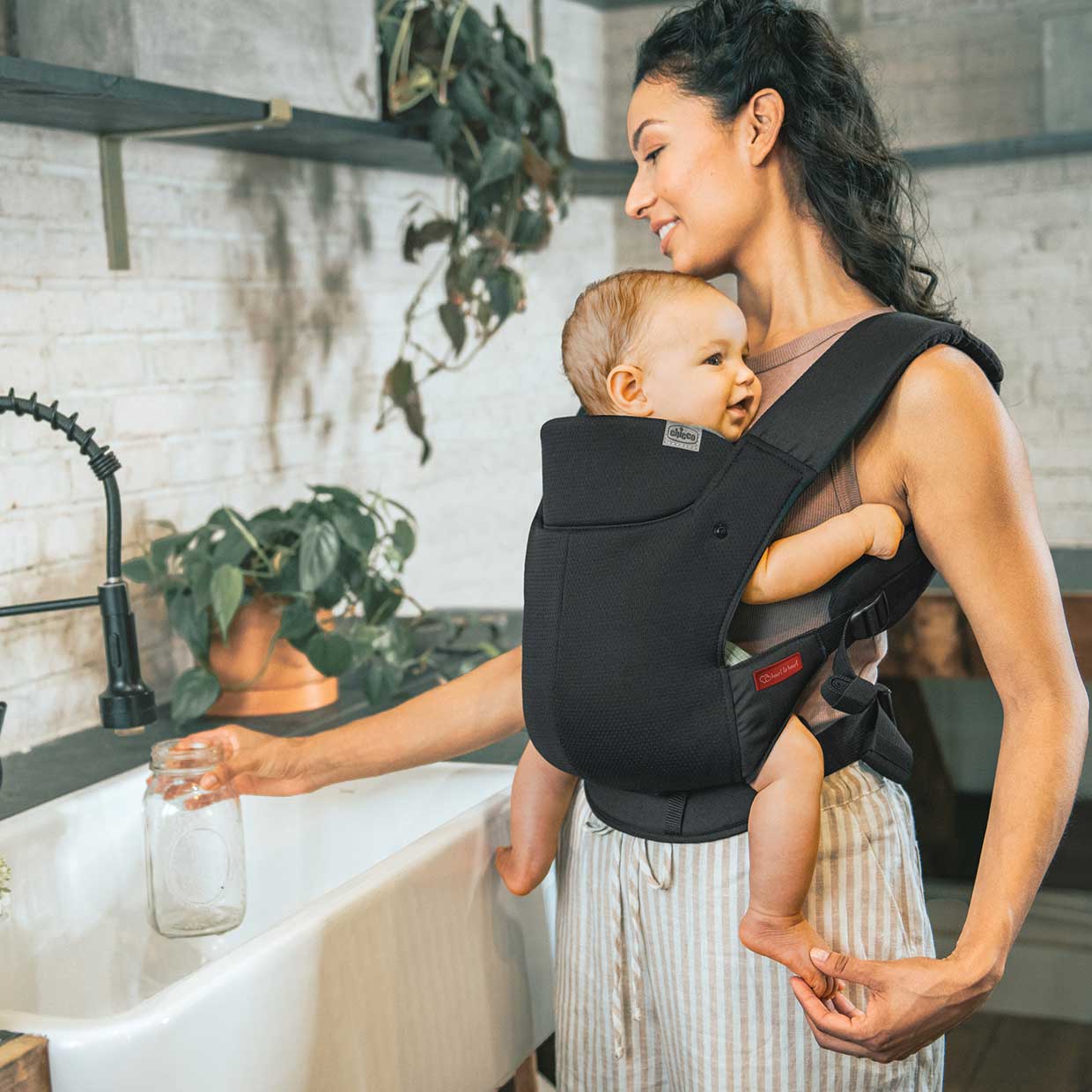 Mother using a Chicco SnugSupport Baby Carrier with infant image