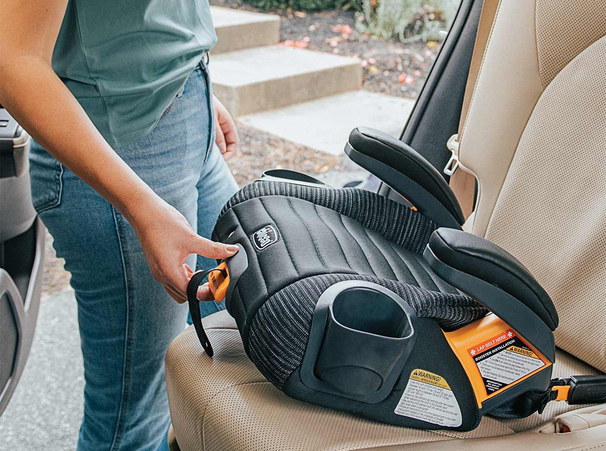 Mom installing Chicco GoFit ClearTex Plus Backless Booster Car Seat image