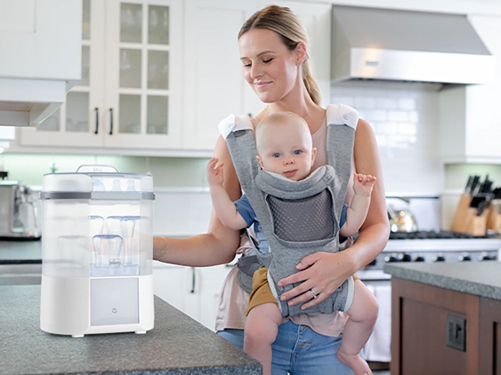 Mother with infant baby using the Chicco Baby Bottle Sterilizer