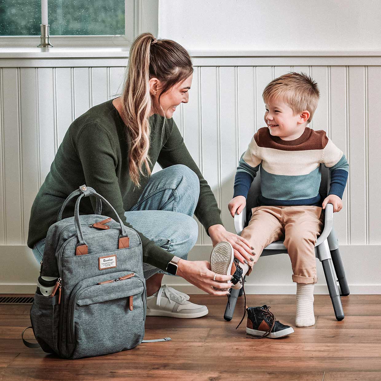 Mother helping toddler sitting in a Chicco Zest 4-in-1 Folding High Chair