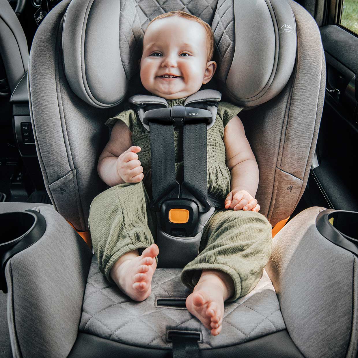 Baby sitting in a Chicco OneFit Max ClearTex All-in-One Car Seat in rear-facing mode